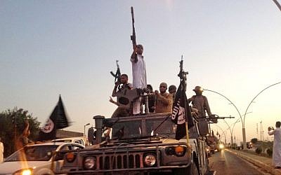 Fighters from the Islamic State group parade in a commandeered Iraqi security forces armored vehicle down a main road at the northern city of Mosul, June 23, 2014. (photo credit: AP/File)