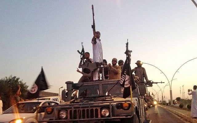 Fighters from the Islamic State group parade in a commandeered Iraqi security forces armored vehicle down a main road at the northern city of Mosul, June 23, 2014. (photo credit: AP/File) Fighters from the Islamic State group parade in a commandeered Iraqi security forces armored vehicle down a main road at the northern city of Mosul, June 23, 2014. (photo credit: AP/File)