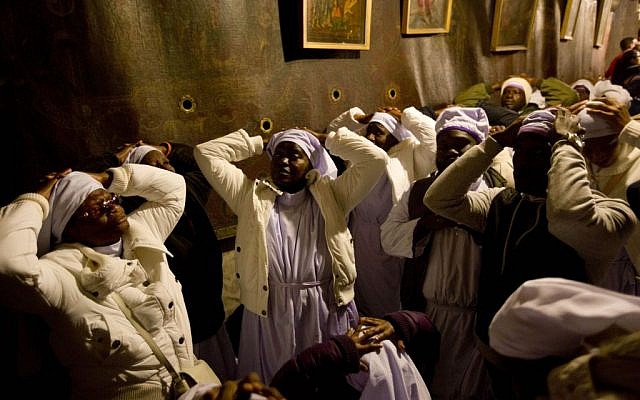 Christian pilgrims from Nigeria pray inside the Grotto of the Church of the Nativity, traditionally believed by Christians to be the birthplace of Jesus Christ, in the West Bank city of Bethlehem on Christmas Eve Wednesday, Dec. 24, 2014. (photo credit: AP Photo/Majdi Mohammed)