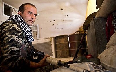 Zinar, a Kurdish sniper takes a quick break from his position, November. 20, 2014 Kobani, Syria. (photo credit: AP/Jake Simkin)