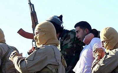 Members of the Islamic State group with a captured pilot, center, wearing a white shirt in Raqqa, Syria, Wednesday, Dec. 24, 2014. (photo credit: AP/Raqqa Media Center of the Islamic State group) 