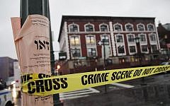 Crime scene tape is wrapped around a pole in front of Chabad-Lubavitch Hasidic headquarters, Tuesday, Dec. 9, 2014, in New York. A knife-wielding man stabbed an Israeli student there before being fatally shot by police after he refused to drop the knife. The student, Levi Rosenblatt, is in stable condition. (photo credit: AP Photo/Mark Lennihan)