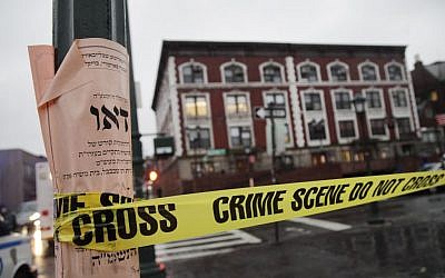 'Crime scene' tape is wrapped around a pole in front of Chabad-Lubavitch Hasidic headquarters in New York, December 9, 2014. (photo credit: AP/Mark Lennihan)