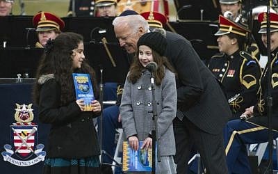 Vice President Joe Biden talks to Basya Fogelman, 9, of Wilkes Barre, Pa, right, and Simmy Hershkop, 11, of Wooster, Ma., left, after they read their winning essays on what Hanukkah means to them as they participate in the annual National Menorah Lighting during a ceremony marking the start of the celebration of Hanukkah, on the Ellipse near the White House in Washington, Tuesday, Dec. 16, 2014. (Photo credit: AP/Cliff Owen)