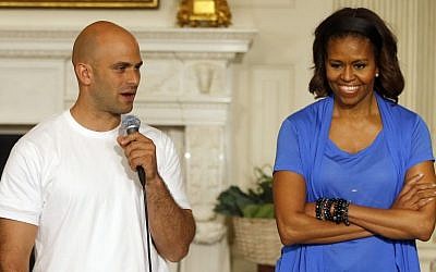 First lady Michelle Obama stands with chef Sam Kass, recently resigned White House senior policy adviser for nutrition policy, at the White House in Washington, DC,  June 12, 2104. (photo credit: AP/Charles Dharapak, File)