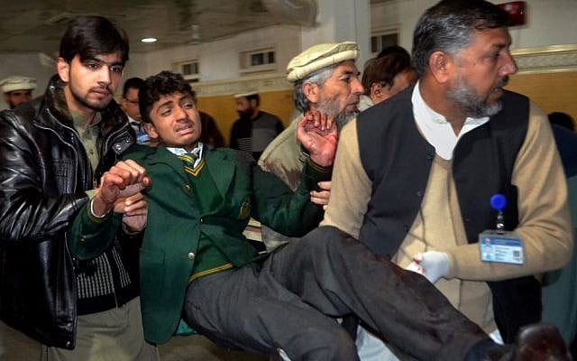 Pakistani volunteers carry a student at a local hospital after he was injured during a shootout at a school under attack by Taliban gunmen,  in Peshawar, Pakistan, Tuesday, Dec. 16, 2014. (photo credit:AP/Mohammad Sajjad)