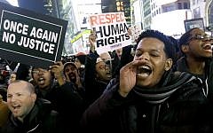 Protesters shout in Times Square after the announcement that the New York City police officer involved in the death of Eric Garner is not being indicted, December 3, 2014. (photo credit: AP/Julio Cortez)