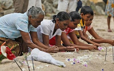 Sri Lankan tsunami survivors pay their respect at a mass grave of 591 train passengers which was hit by 2004 tsunami in Peraliya, Sri Lanka, Friday, Dec. 26, 2014. (Photo credit: AP/Eranga Jayawardena)
