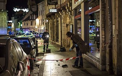 A policewoman collects evidence on December 21, 2014 in Dijon on the site where a driver shouting "Allahu Akbar" ("God is great") ploughed into a crowd injuring 11 people, two seriously, a source close to the investigation said. (photo credit: AFP PHOTO / ARNAUD FINISTRE)