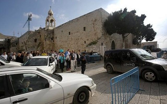 In this Sunday, Dec. 14, 2014, photo tourists walks and cars drive past the Church of the Nativity in Bethlehem, West Bank. (photo credit: AP Photo/Nasser Shiyoukhi) In this Sunday, Dec. 14, 2014, photo tourists walks and cars drive past the Church of the Nativity in Bethlehem, West Bank. (photo credit: AP Photo/Nasser Shiyoukhi)