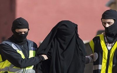 Spanish police escort a 20-year-old Abaya clad woman in Melilla on December 16, 2014 during the combined arrests of seven people in Spain and Morocco for allegedly recruiting young women via the Internet to join the jihadist Islamic State group fighting in Iraq and Syria. (AFP)