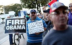 People stand outside the Little Havana restaurant Versailles, as they absorb the news that Alan Gross was released from a Cuban prison and that US President Barack Obama wants to change the United States Cuba policy, Dec. 17, 2014 in Miami. (photo credit: Joe Raedle/Getty Images)