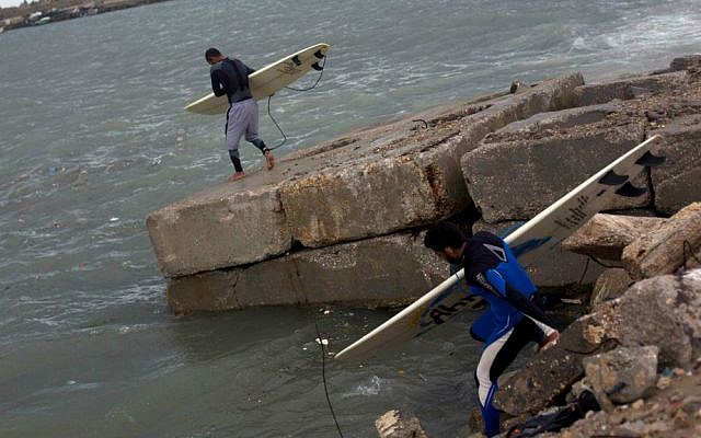 In this Thursday November 27, 2014 photo, Palestinians Mohammed Abu Jayyab, 41, and Ahmed Abu Hasira, 35, walk with their boards into the water to surf in Gaza City. (photo credit: AP Photo/Khalil Hamra) In this Thursday November 27, 2014 photo, Palestinians Mohammed Abu Jayyab, 41, and Ahmed Abu Hasira, 35, walk with their boards into the water to surf in Gaza City. (photo credit: AP Photo/Khalil Hamra)