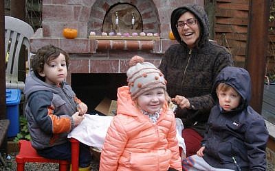 Sarabel Eisenfeld, the founder of Gan Shalom, and her Portland Jewish preschoolers grating potatoes outside for Hanukkah latkes. (Anthony Weiss/JTA)