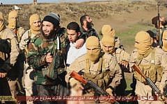 A picture released by the Islamic State purporting to show members of the group holding a captive Jordanian pilot. Wednesday, December 24, 2014 (screen capture: YouTube)