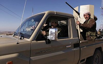 Iraqi Kurdish forces head to battle Islamic State fighters, on the summit of Mount Sinjar, in Iraq, Sunday, Dec. 21, 2014 (photo credit: AP/Dalton Bennett)
