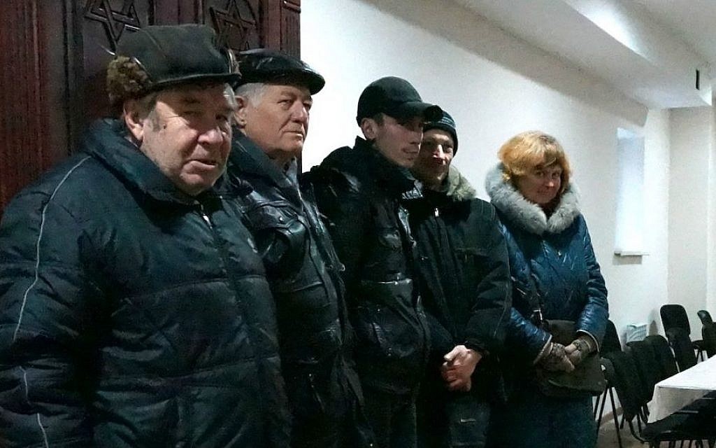 Members of the Lugansk Jewish community standing in front of their synagogue's Torah ark, Dec. 11, 2014. (Cnaan Liphshiz/JTA) Members of the Lugansk Jewish community standing in front of their synagogue's Torah ark, Dec. 11, 2014. (Cnaan Liphshiz/JTA)