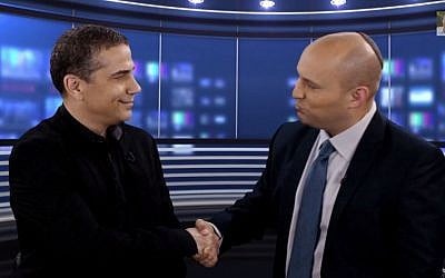 Journalist Yinon Magal (L) shakes hands with Jewish Home Party leader Naftali Bennett (R) after declaring his intention to join the party, December 27, 2014. (screen capture: YouTube/Naftali Bennett)