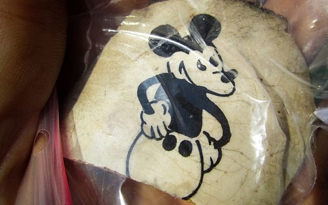 Fragment of a ceramic cup excavated at the former Nazi death camp Sobibor, with an image of Mickey Mouse. The artifact was unearthed by archeologists Wojtek Mazurek and Yoram Haimi in 2014 (Matt Lebovic/The Times of Israel).