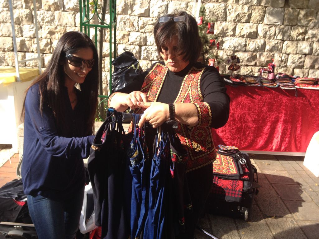 Maisoon Zoabi choosing hand-embroidered tanktops (photo credit: Jessica Steinberg/Times of Israel)