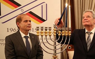 Illustrative: Israeli Ambassador to Germany Yakov Hadas-Handelsman watches as German President Joachim Gauck lights a menorah during a ceremony to mark 50 years of ties between Israel and Germany on December 18, 2014. (photo credit: Ministry of Foreign Affairs)