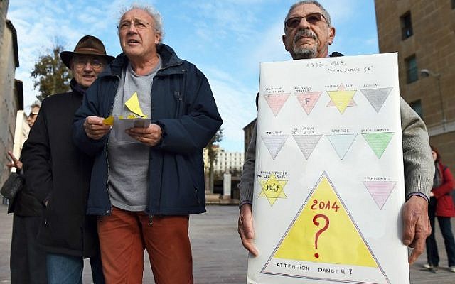 protestor A demonstrator holds a sign in front of the City Hall of Marseille, southern France, on December 3, 2014, during a demonstration against a "security badge" distributed to homeless people in Marseille. (photo credit: AFP/Anne-Christine Poujoulat)