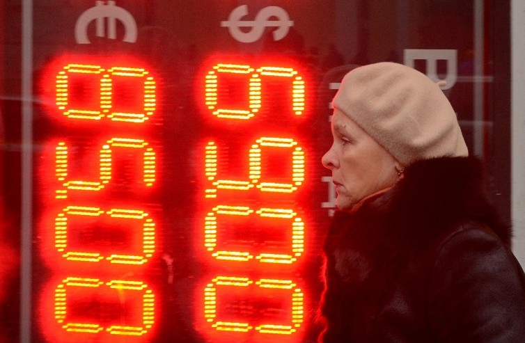A woman walks past a board listing foreign currency rates against the Russian ruble outside an exchange office in central Moscow on December 16, 2014. (Photo credit: AFP/ Kirill Kudryavtsev) A woman walks past a board listing foreign currency rates against the Russian ruble outside an exchange office in central Moscow on December 16, 2014. (Photo credit: AFP/ Kirill Kudryavtsev)