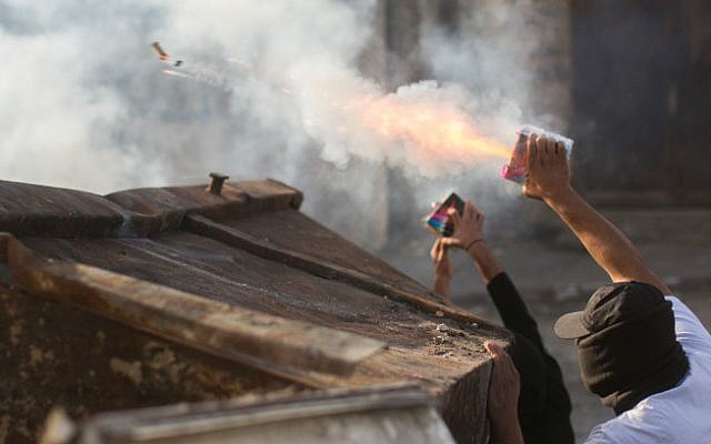 Two teens shooting fireworks at police forces on Friday November 7, 2014 in Shuafat Refugee Camp (photo credit: Yonantan Sindel/ Flash 90) Two teens shooting fireworks at police forces on Friday November 7, 2014 in Shuafat Refugee Camp (photo credit: Yonantan Sindel/ Flash 90)