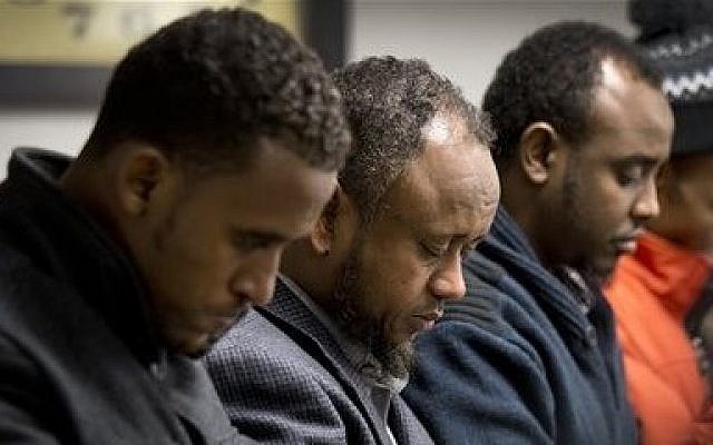 Men gather to pray the day after 15-year-old Abdisamad Sheikh-Hussein was struck and killed by a hit-and-run driver in front of the Somali Center of Kansas City, Mo., Friday, Dec. 5, 2014. (photo credit: AP Photo/The Kansas City Star, Keith Myers) Men gather to pray the day after 15-year-old Abdisamad Sheikh-Hussein was struck and killed by a hit-and-run driver in front of the Somali Center of Kansas City, Mo., Friday, Dec. 5, 2014. (photo credit: AP Photo/The Kansas City Star, Keith Myers)
