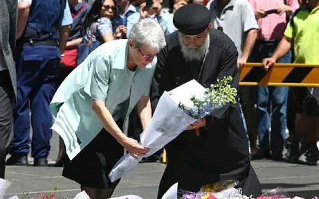 People lay flowers to pay respect to the shooting victims at a makeshift memorial in Sydney, Australia, on December 16, 2014 (photo credit: AP/Photo/Steve Christo) People lay flowers to pay respect to the shooting victims at a makeshift memorial in Sydney, Australia, on December 16, 2014 (photo credit: AP/Photo/Steve Christo)