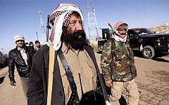 Yazidi fighters head to battle Islamic State militants, on the summit of Mount Sinjar, in Iraq, Sunday, Dec. 21, 2014. (Photo credit: AP/Dalton Bennett)