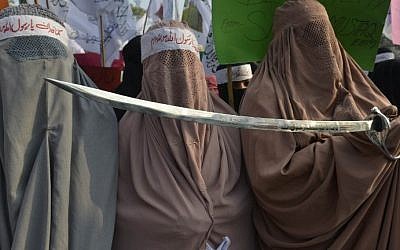 Pakistan women demonstrators wear burqas and hold a sword in protest against the printing of satirical sketches of the Prophet Muhammad by French magazine Charlie Hebdo, in Lahore on January 20, 2015. Pakistan's parliament on January 15 condemned French satirical magazine Charlie Hebdo for printing a "blasphemous" cartoon of the Prophet Muhammad. (photo credit: Arif Ali/AFP)
