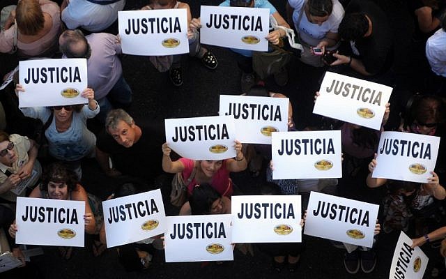 Citizens hold placards that read "Justice" during a rally in front of the headquarters of the AMIA (Argentine Israelite Mutual Association), in Buenos Aires on January 21, 2015. Citizens hold placards that read "Justice" during a rally in front of the headquarters of the AMIA (Argentine Israelite Mutual Association), in Buenos Aires on January 21, 2015.