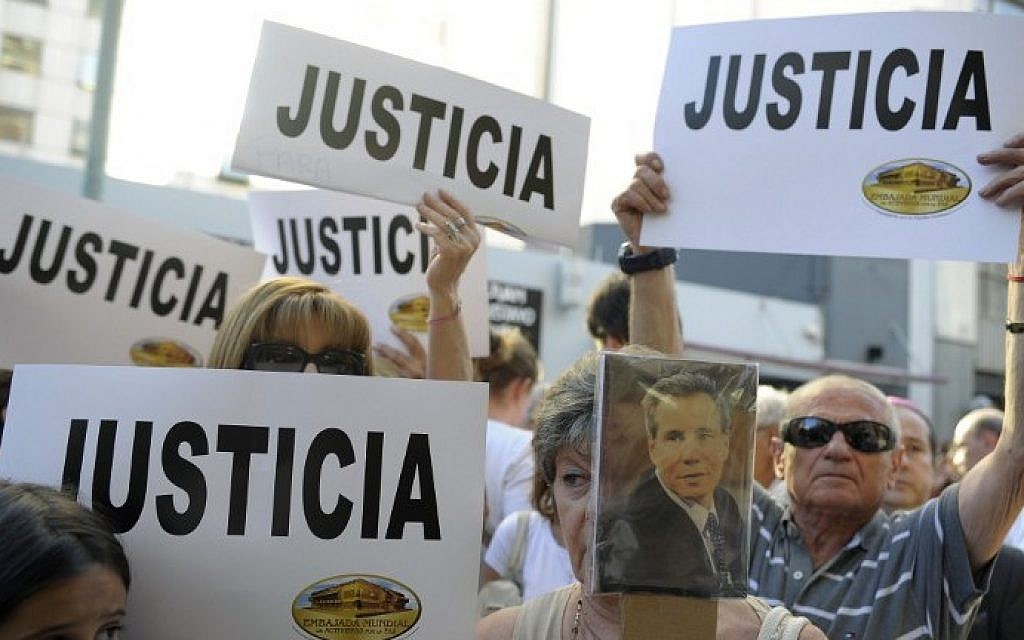 People hold placards that read 'Justice' during a rally in front of the headquarters of the AMIA (Argentine Israelite Mutual Association), in Buenos Aires on January 21, 2015. (photo credit: Alejandro Pagni/AFP)