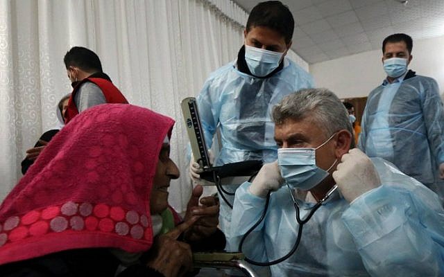 Doctors tend to Yazidi people at al-Tun Kopri health center, located half way between the northern Iraqi city of Kirkuk and Irbil, after they were released by the Islamic State with around 200 mostly elderly members of Iraq's Yazidi minority near Kirkuk on January 17, 2015. (photo credit: AFP/Safin Hamid)