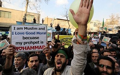Iranians take part in a protest against the printing of satirical sketches of the Prophet Muhammad by French satirical weekly Charlie Hebdo on January 19, 2015 outside the French embassy in Tehran. The demonstration was in response to a cartoon published in the latest issue of Charlie Hebdo showing on its cover the prophet Mohammed holding a "Je Suis Charlie" (I am Charlie) sign under the headline "All is forgiven", a week after a January 7 attack at its Paris headquarters killed 12 people. (photo credit: Atta Kenare/AFP)