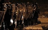 Israeli police stand guard during clash with Arab-Israeli protester in the southern Israeli Bedouin city of Rahat on January 20, 2015. (photo credit: AFP PHOTO / AHMAD GHARABLI)