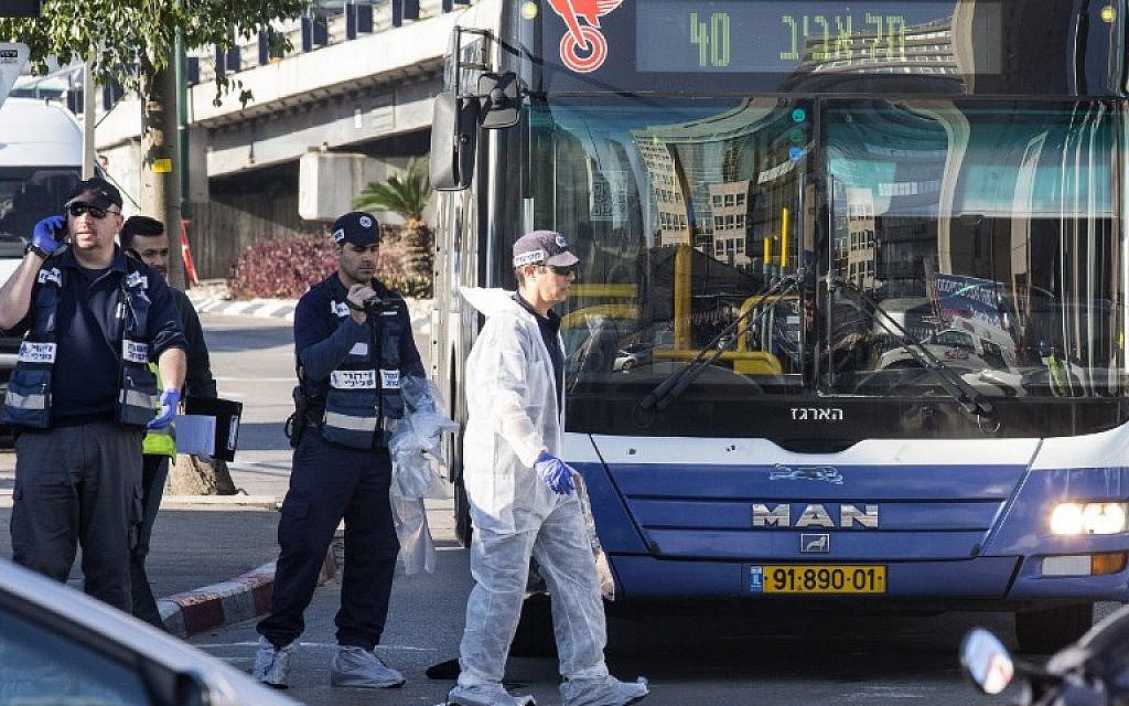 Israeli forensics examine the scene of an attack after a Palestinian man stabbed several people on a Tel Aviv bus on January 21, 2015. (photo credit:AFP/JACK GUEZ)