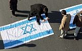 Illustrative: Iranian protesters pour kerosene on an Israeli flag during the funeral procession of Brigadier General Mohammad Ali Allahdadi in Tehran on January 21, 2015. (AFP/Atta Kenare)