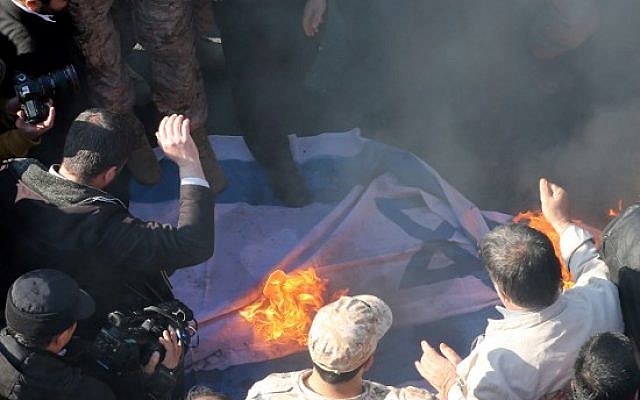 Iranian protesters set an Israeli flag on fire during the funeral procession of Brigadier General Mohammad Ali Allahdadi in Tehran on January 21, 2015. (Photo credit: AFP/ATTA KENARE)