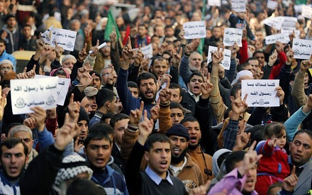 Palestinians hold placards and shout slogans praising Islam's Prophet Muhammad during a demonstration organized by Islamist movement Hamas against the cover cartoon of the Prophet published by French satirical magazine Charlie Hebdo, on January 23, 2015 in Jabaliya refugee camp in the northern Gaza Strip (photo credit: AFP/MOHAMMED ABED)