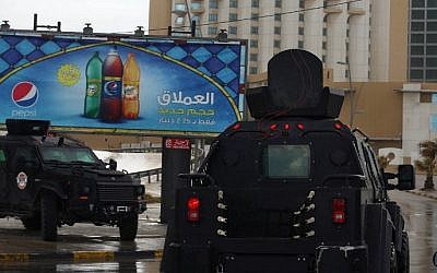 Libyan security forces surround Tripoli's central Corinthia Hotel (R) on January 27, 2015 in the Libyan capital. (photo credit: Mahmud Turkia/AFP)