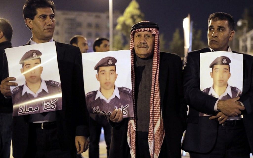 Relatives of Jordanian air force pilot Moaz al-Kasasbeh, who crashed in Syria with an F-16 in 2014, carry posters with his portrait and a slogan reading in Arabic, “we are all Moaz”, during a protest near the Prime Minister office in Amman late on January 27, 2015 demanding the release of Sajida al-Rishawi, an Iraqi female suicide bomber on death row in Jordan. (AFP PHOTO / KHALIL MAZRAAWI)