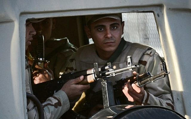 Egyptian members of the armed forces patrol outside al-Maza military airport where the bodies of the members of security forces, who were killed in North Sinai province during an attack the day before, had been flown on January 30, 2015 in the capital Cairo. (Photo credit: AFP/ MOHAMED EL-SHAHED)