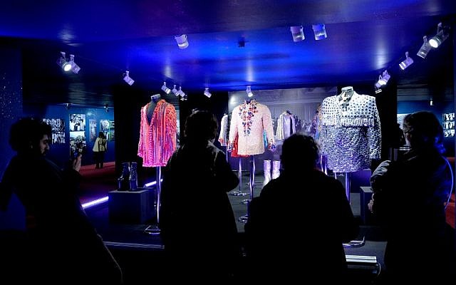 A picture taken on December 20, 2014 in Istanbul shows people looking at costumes worn by late singer Zeki Muren displayed as part of the "Here I am, Zeki Muren" exhibition. (photo credit:AFP/OZAN KOSE)