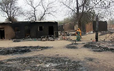A woman walking past burnt houses after a two-day clash between officers of the Joint Task Force and members of the Islamist sect Boko Haram, in Baga, Borno, April 21, 2013. (photo credit: AFP PHOTO/STRINGER)