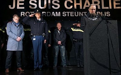 Mayor of Rotterdam, Ahmed Aboutaleb (R), chief-editor of Dutch newspaper Algemeen Dagblad Christiaan Ruesink (L) and Frank Pauw (C) deputy chief constable of the police in Rotterdam observe a minute of silence in front of a banner reading 'I am Charlie' at Square 1940, in Rotterdam on January 8, 2015. (photo credit: Jerry Lampen/AFP)