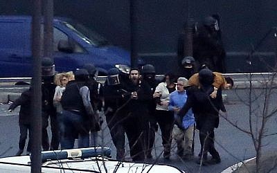 A security officer directs released hostages after they stormed a kosher market to end a hostage situation, Paris, Friday, Jan. 9, 2015.  (Photo credit: AP/Michel Euler)