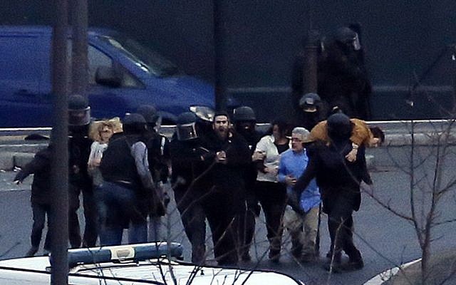 A security officer directs released hostages after they stormed a kosher market to end a hostage situation, Paris, Friday, Jan. 9, 2015.  (Photo credit: AP/Michel Euler)