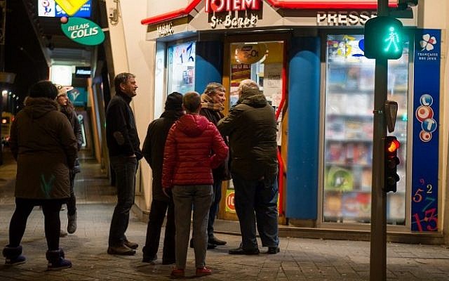 People wait outside a newsagents in Dunkirk as the latest edition of French satirical magazine Charlie Hebdo goes on sale, January 14, 2015 . (photo credit: AFP/PHILIPPE HUGUEN) 